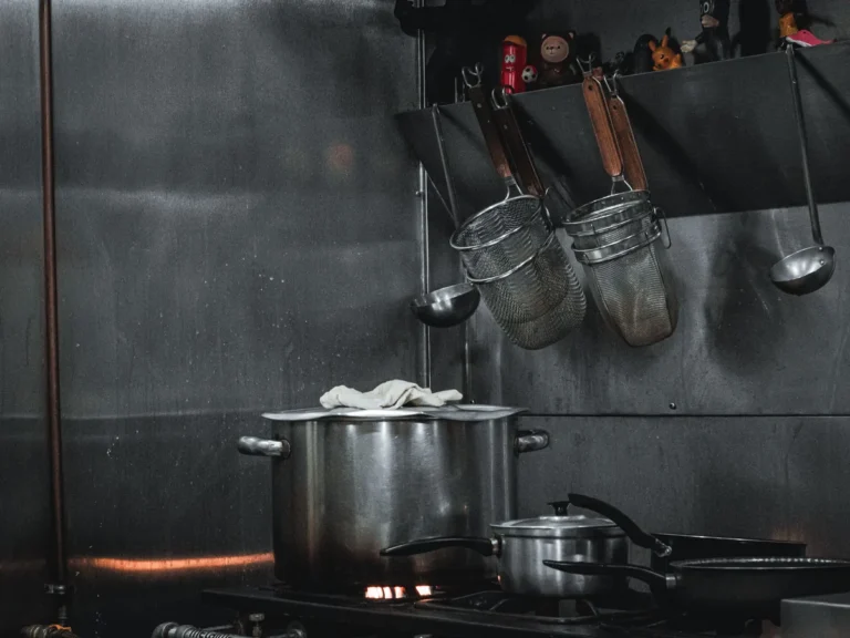 Stainless-steel cooking equipment, pots, and utensils in a commercial kitchen