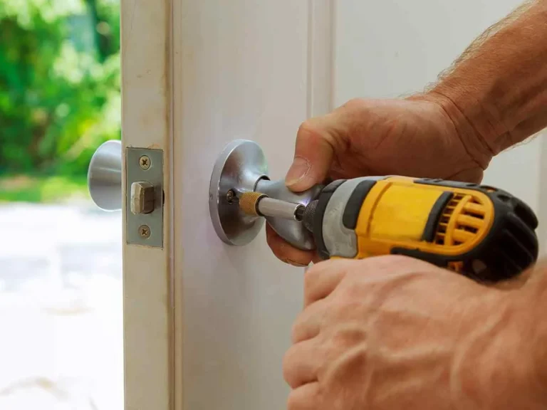 Technician using a drill to repair commercial door hardware